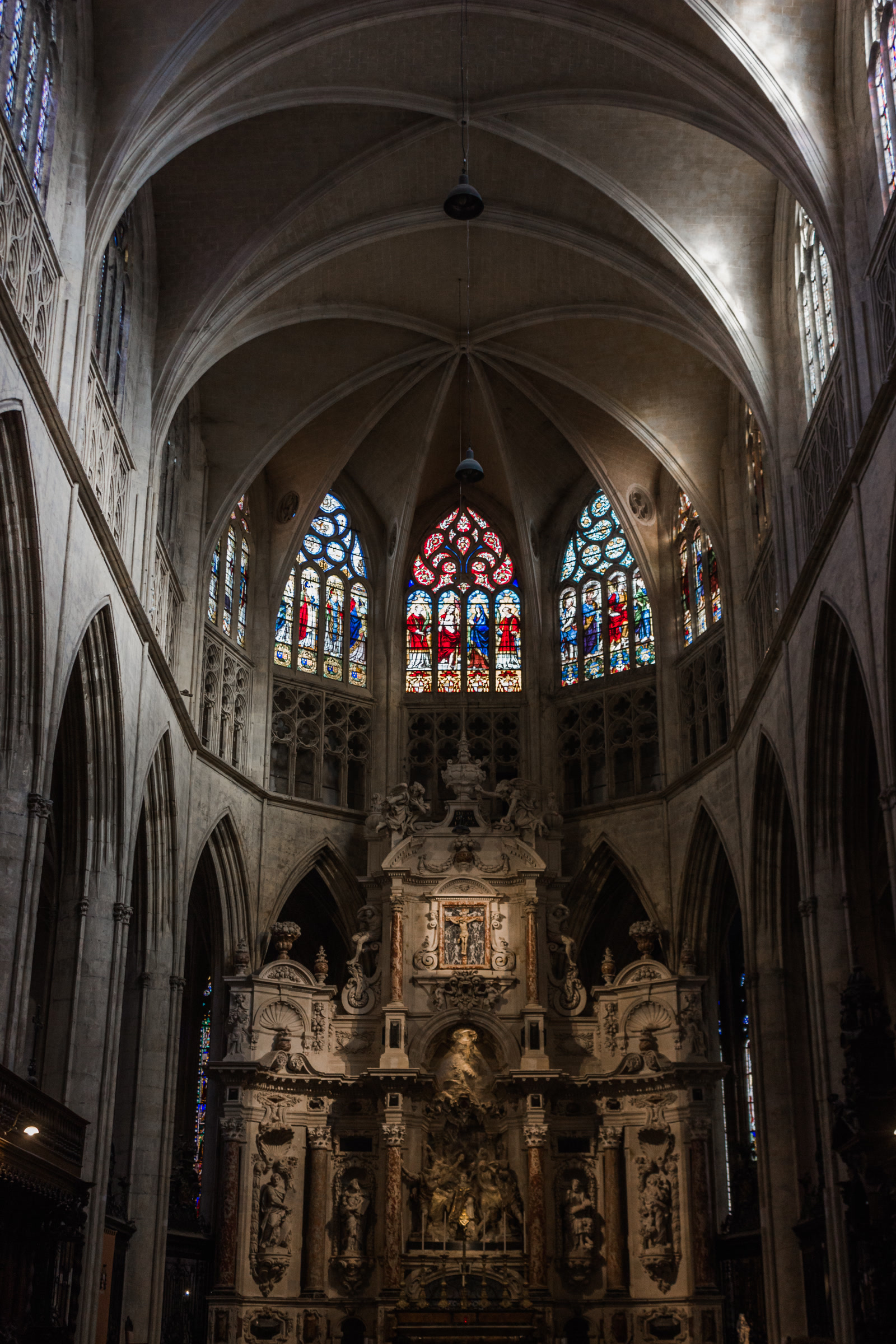 Shadowed cathedral interior with stained glass